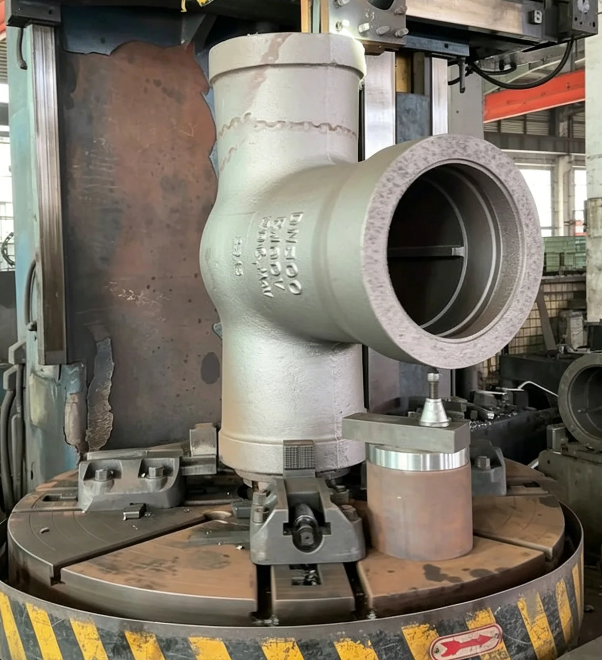 Large valve body mounted on machine tooling in the machining workshop