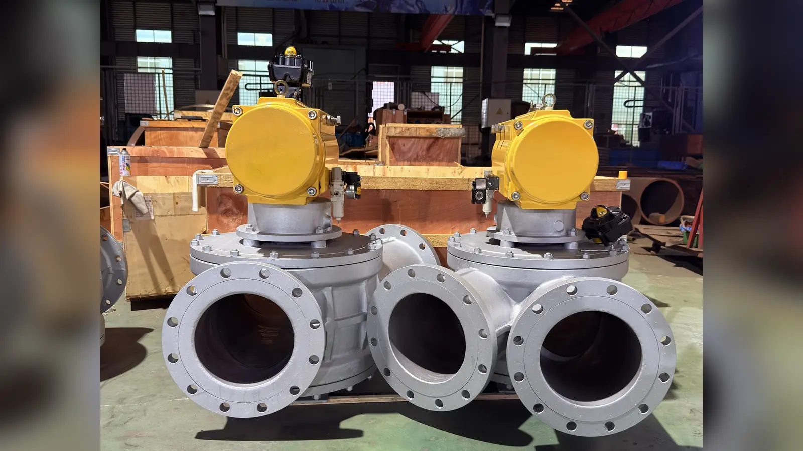 Two completed three-way dust diverter valves with pneumatic actuators in the workshop
